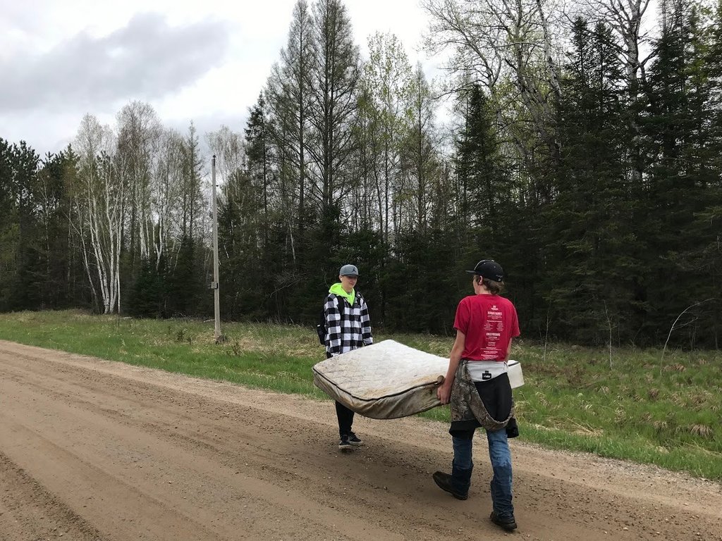 Students carrying a mattress
